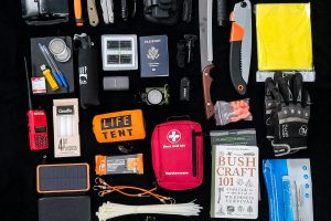 Survival gear essentials arranged as a flat lay for camping and hiking preparedness.